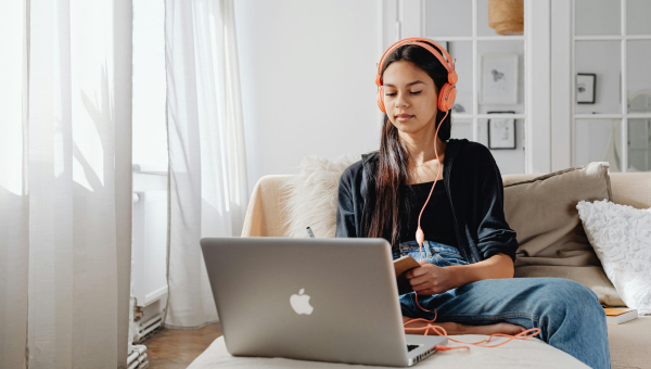 Das Bild von Karolia Grabowska zeigt ein junges Mädchen mit Kopfhörern beim e-Learning.